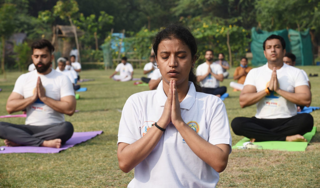 People perform Yoga, on the occasion of the 7th International Day of Yoga 2021, at Wazirabad in Delhi on June 21, 2021.