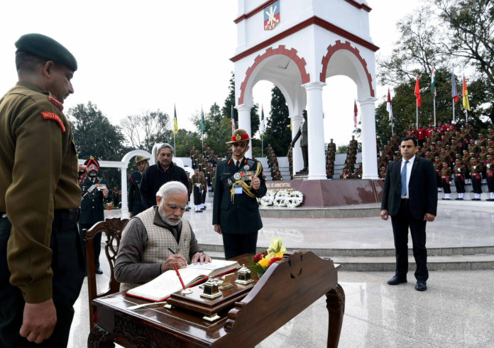 The Prime Minister, Shri Narendra Modi signing visitors book at the War Memorial in Indian Military Academy, Dehradun, ahead of the Combined Commanders Conference, on January 21, 2017. The Union Minister for Defence, Shri Manohar Parrikar is also seen.
