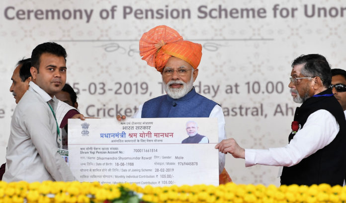 The Prime Minister, Shri Narendra Modi distributing the PM-SYM Pension Cards to select beneficiaries, at a function, in Vastral, Gujarat on March 05, 2019. The Minister of State for Labour and Employment (I/C), Shri Santosh Kumar Gangwar is also seen.