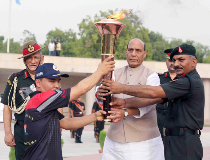 The Union Minister for Defence, Shri Rajnath Singh handing over the Victory Flame (mashal) of Kargil War to the first torch bearer army shooter Subedar Jitu Rai to be carried by Indian Armys outstanding sportsmen and war heroes to Kargil War Memorial, at Dras, in New Delhi on July 14, 2019. The Chief of Army Staff, General Bipin Rawat is also seen.