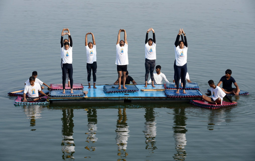Students of a Water Club perform Yoga, on the occasion of the 7th International Day of Yoga 2021, at Yamuna River, in Delhi on June 21, 2021.