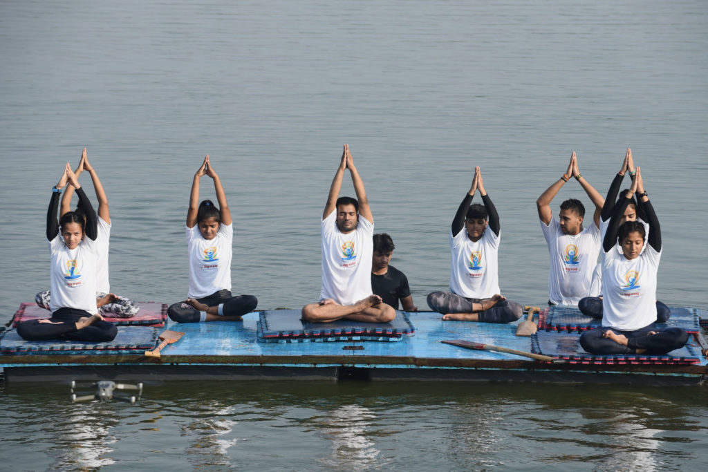 Students of a Water Club perform Yoga, on the occasion of the 7th International Day of Yoga 2021, at Yamuna River, in Delhi on June 21, 2021.