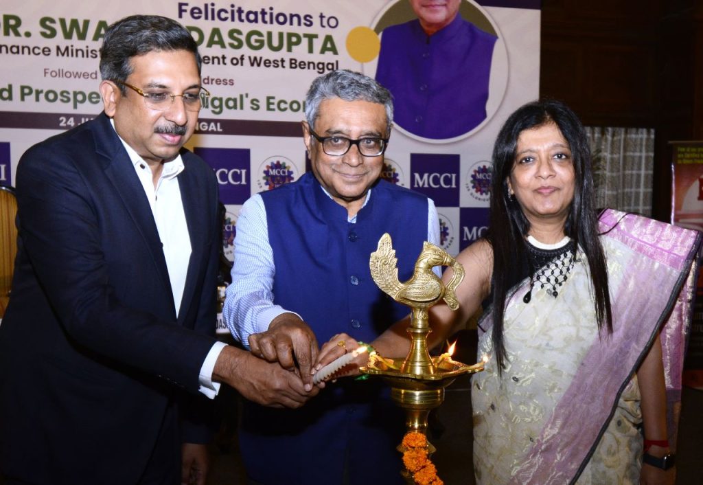 Lighting of the Lamp : (L - R) - Shri Munish Jhajharia, Senior Vice President, MCCI, Dr. Swapan Dasgupta, Hon'ble Minister of Finance, Government of West Bengal, Smt. Priti A. Sureka, President, MCCI at the Felicitations & Special Session with Dr. Swapan Dasgupta, Hon'ble Minister of Finance Government of West Bengal on "Improved Prospects of Bengal's Economy" held Today, 24 July 2026 at Crystal Hall, Taj Bengal.