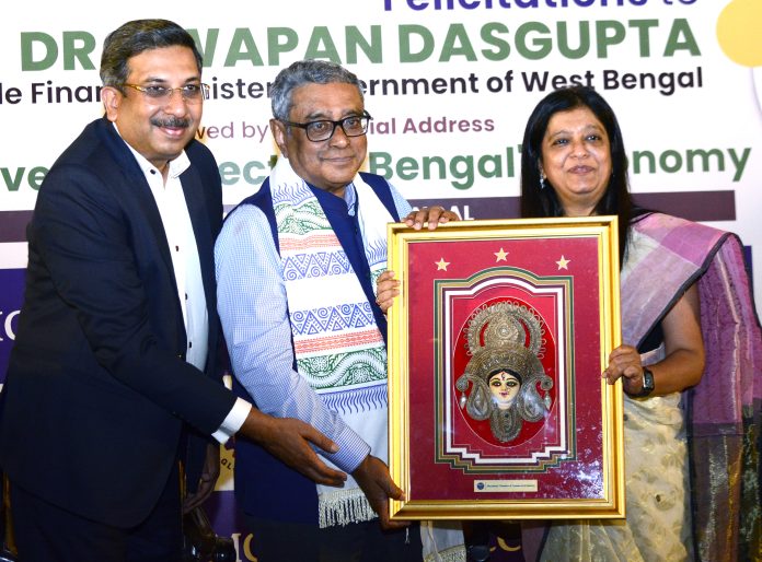 L- R : Shri Munish Jhajharia, Senior Vice President, MCCI and Smt. Priti A. Sureka, President, MCCI presenting a memento to Dr. Swapan Dasgupta, Hon'ble Minister of Finance, Government of West Bengal, at the Felicitations & Special Session with Dr. Swapan Dasgupta, Hon'ble Minister of Finance Government of West Bengal on "Improved Prospects of Bengal's Economy" held Today, 24 July 2026